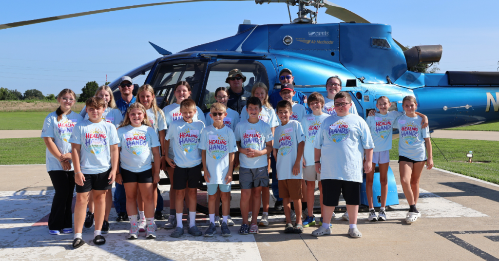 Healing Hands Summer Camp Students Standing by ARCH Helicopter