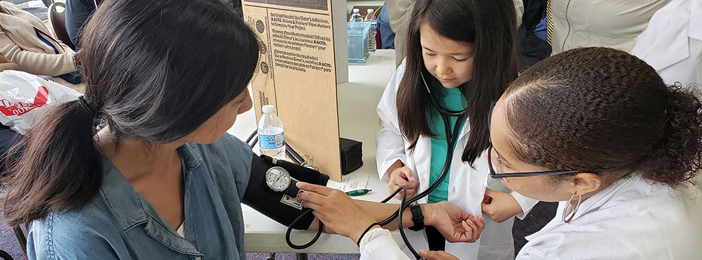 Young Doctors Club members learn to take a blood pressure reading.