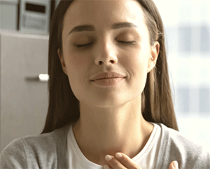 A young woman with eyes closed, and a dreamy, interior-looking expression.