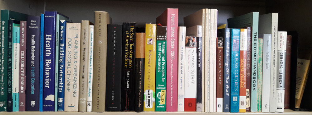 A bookshelf with books on a range of issue relating to healthcare and health organizations.