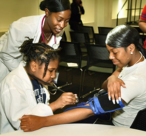 Young women learning to take pulse and blood pressure.