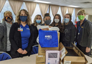 Our team, masked up, poses with donation items.
