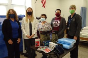 Our team, masked up, poses with donation items.