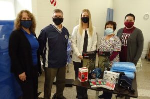 Our team, masked up, poses with donation items.