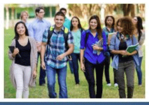 Students walking with their books and backpacks on a grassy lawn.