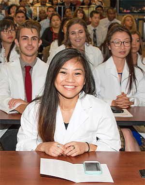 White-coated PharmD students in class.