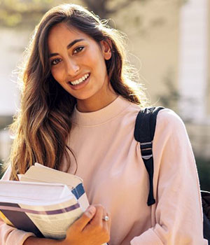 Young woman student with knapsack and textbooks.