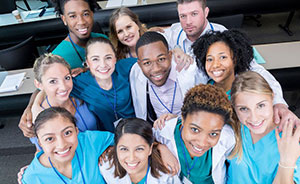 Students in scrubs post for a group photo.