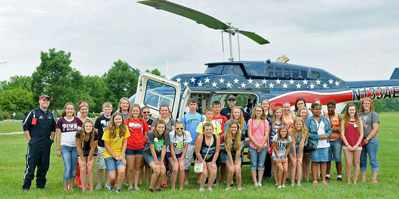 Students in Rend Lake College Discovery Health Camp pose for a group shot in front of a helicopter.