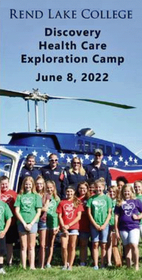 Camp participants pose in front of a medevac helicopter.