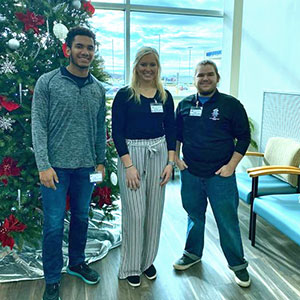 Three high school students from Steeleville, Illinois, who took part in job shadowing at Pinckneyville Community Hospital pose by the facility's Christmas tree.